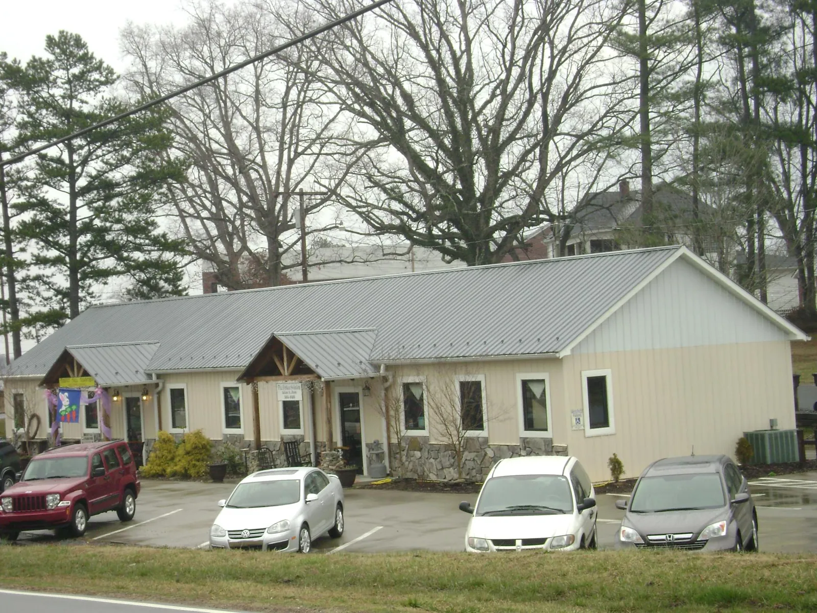 Gray metal roof with timber entry brackets on a small commercial building in Prineville
