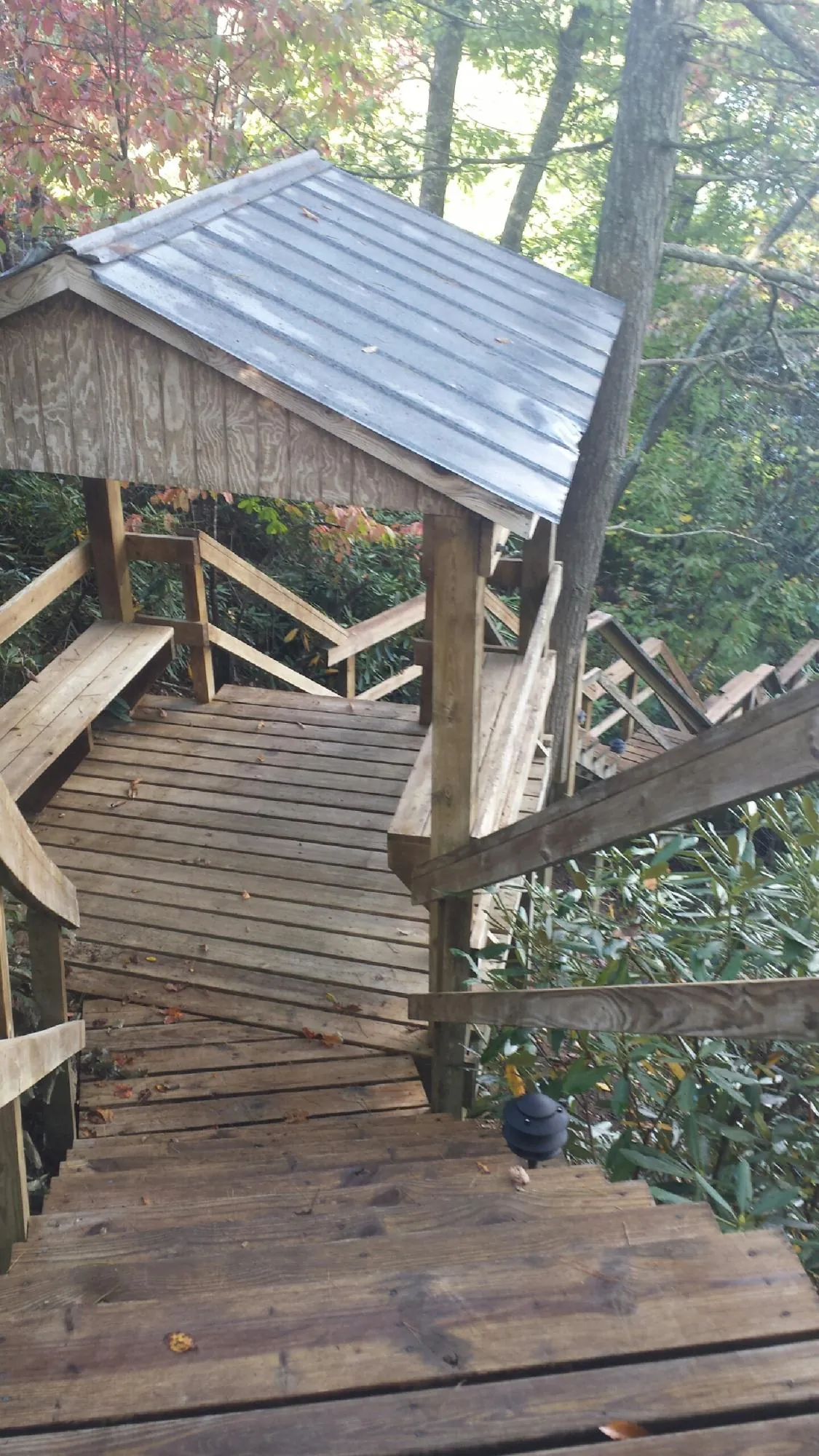 Metal roofed shelter over wooden steps on a wooded walkway — Skylight Repair & Installation work by our crew in Prineville