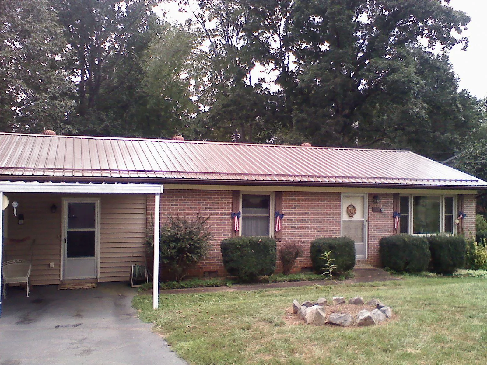 Bronze metal roof and carport on a brick ranch home — Roof Repair work by our crew in Prineville